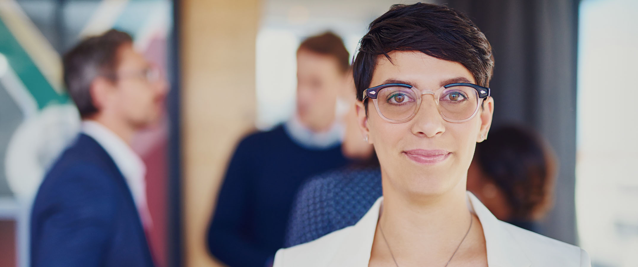 Image of a professional woman with short dark hair and glasses, looking confidently at the camera.